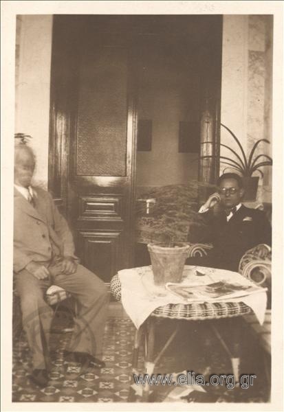 Portrait of two men inside a house.