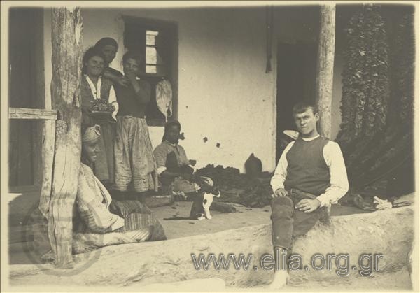 Peasant women in Nigrita processing tobacco. Next to them, a French soldier posing barefoot.