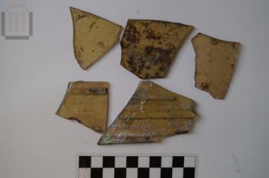 Blown glasspane fragment with inserted material and incised decoration remaints