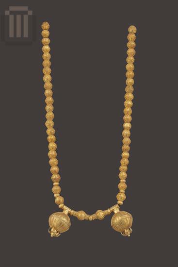 Two gold pendants from a necklace in the shape of pomegranates