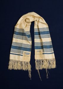 Prayer shawl, cream silk with steel blue stripes along the edge, cream square corner reinforcements, given to David Salario for his Bar Mitzvah, Smyrna.