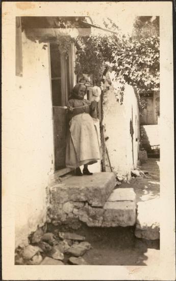 Skyros. Old woman spinning outside her front door
