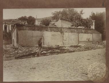 Έλληνας στρατιώτης μπροστά από ερείπια σπιτιού.