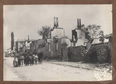 Παιδιά και δύο άνδρες μπροστά από ερείπια κεντρικής οδού της πόλης του Δοξάτου.