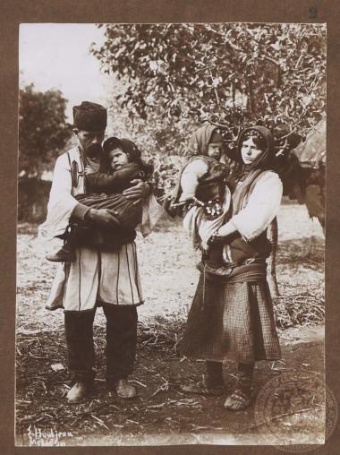 Ζευγάρι χωρικών (πιθανότατα προσφύγων) κρατούν αγκαλιά τα μωρά παιδιά τους.