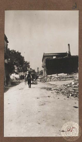 Κάτοικος με άμαξα σε κατεστραμμένη οδό της πόλης του.