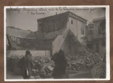 Ένας άνδρας, μια γυναίκα και ένας ιερέας μπροστά σε χαλάσματα σε κεντρικό δρόμο στο Αϊβαλί (Κυδωνίες).