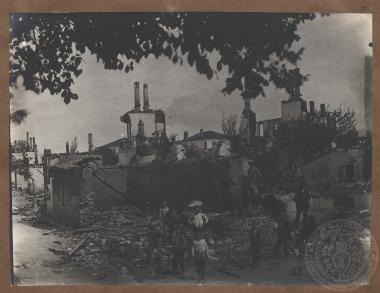 Μικρά παιδιά και άνδρες στα χαλάσματα κεντρικής γειτονιάς του Δοξάτου.