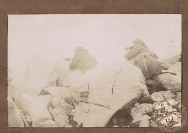 Εύζωνες με τα όπλα προτεταμένα και οχυρωμένοι πίσω από πέτρινους όγκους, έτοιμοι για μάχη.