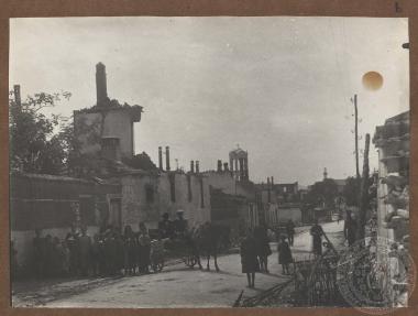 Γυναικόπαιδα, ως επί το πλείστον, μπροστά από χαλάσματα κεντρικής οδού της πόλης του Δοξάτου.