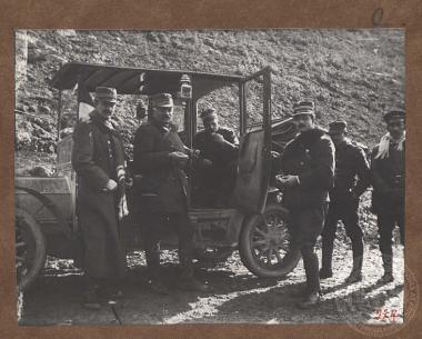 Έξι Έλληνες αξιωματικοί, μέλη του Επιτελείου, τρώνε πρόχειρα μπροστά από αυτοκίνητο.