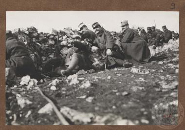 Έλληνες στρατιώτες και αξιωματικοί οχυρωμένοι πίσω από πέτρινο παρατηρητήριο, πιθανόν στο μέτωπο της Ηπείρου.