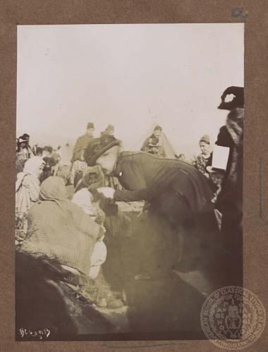 Η Βασίλισσα Όλγα συνομιλεί με γυναίκες και παιδιά σε προσφυγική κατασκήνωση.