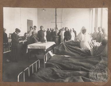 Επίσκεψη αξιωματικών (όρθιοι στο βάθος) σε στρατιωτικό νοσοκομείο.