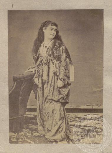 Γυναίκα πολυτελώς ενδεδυμένη, φωτογραφημένη σε όρθια στάση. Φωτογράφιση σε studio.