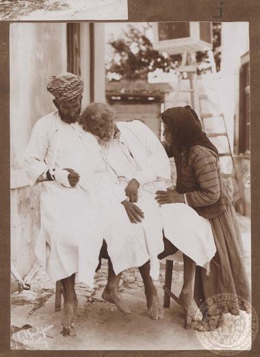 Ηλικιωμένη γυναίκα παρηγορεί καταβεβλημένους τραυματείς.