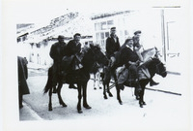 Άντρες καθισμένοι πάνω σε δύο γαϊδούρια