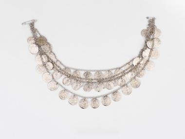 SILVER COINS ON A PIECE OF JEWELLERY WITH CHAIN, PART OF THE TRADITIONAL COSTUME OF ALEXANDREIA WITH A BLUE SAYIAS