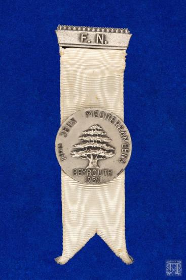 Badge F.N. (Federation National) σε λευκή γκρο κορδέλα, IIIes JEUX MEDITERRANEENS BEYROUTH- 1959 (λευκό μέταλλο)