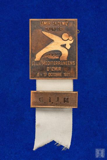 Καρφίτσα με κορδέλα και επιγραφή C.I.J.M JEUX MEDITERRANEENS G’ IZMIR 6-17 OCTOBRE 1971