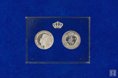 Συλλεκτικά επετειακά αργυρά αναμνηστικά νομίσματα σε πλαστική κασετίνα proof από χάρτινο κουτί συσκευασίας των 3. Αυτό που βρίσκεται στα αριστερά φέρει επιγραφές: στην εμπρόσθια όψη JUAN CARLOS Y SOFIA 1987 και στην οπίσθια M PRUEBA. Αυτό που βρίσκεται στα δεξιά φέρει επιγραφές: στην εμπρόσθια όψη  στο κέντρο, έχει τα μονογράμματα JCS και περιμετρικά,500 PTAS ESPANA και στην οπίσθια M PRUEBA.