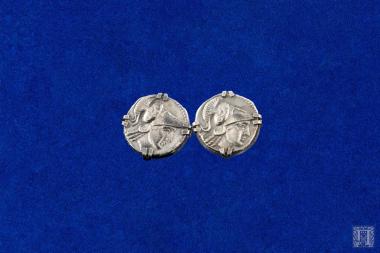 Δύο αργυρά μανικετόκουμπα (φέρουν χτύπημα 900), από αντίγραφο αρχαίου αργυρού νομίσματος, τοποθετημένο με 4 άγκιστρα σε ειδικό στέλεχος.
