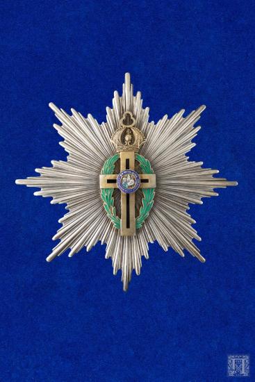 Μεγαλόσταυρος με πράσινο και μπλε σμάλτο σε όψη έχει τέσσερις μεταλλικές υποδοχές για την κορδέλα