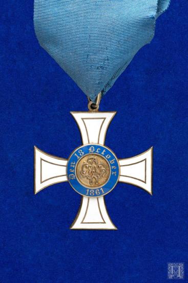 Μετάλλιο με μπλε γκρο κορδέλα και διακόσμηση με λευκό και μπλε σμάλτο. Φέρει  επιγραφή στη μία όψη  “Den 18 October 1861”