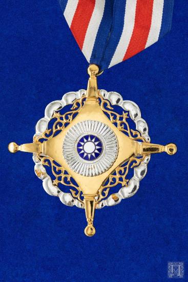 Σύγχρονο μετάλλιο σε ριγέ μπλε, άσπρη, κόκκινη κορδέλα, με το αστέρι της Μακεδονίας στην εμπρόσθια όψη και χτύπημα 102 μαζί με επιγραφές στην κινεζική, στην οπίσθια