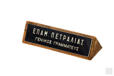Μεταλλική επιγραφή σε ξύλινη πυραμοειδή βάση, ΕΠΑΜ. ΠΕΤΡΑΛΙΑΣ – ΓΕΝΙΚΟΣ ΓΡΑΜΜΑΤΕΥΣ