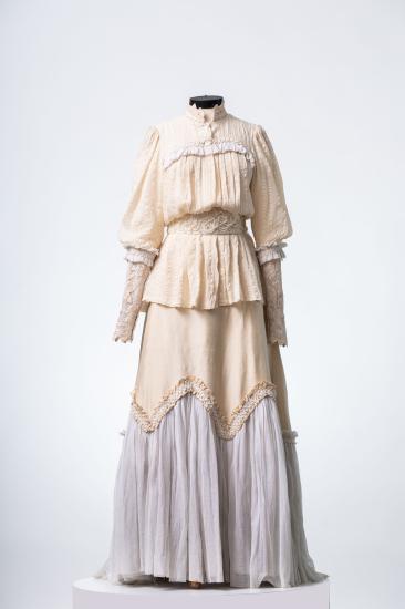 Γυναικείο κοστόυμι αποτελούμενο από πουκαμίσα και φούστα με βολάν και πλισέ, από λινό και βαμβακερό με δαντέλα