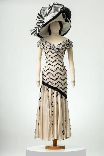 Γυναικείο φόρεμα, μακρύ, αμάνικο, από κρεπ σατέν μεταξωτό και δαντέλα με βολάν και καπέλο