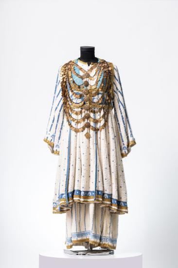 Γυναικείο κοστούμι αποτελούμενο από πουκαμίσα μακριά και φούστα από μπουρνουζέ ύφασμα, φλουριά, αλυσίδες και τρέσες