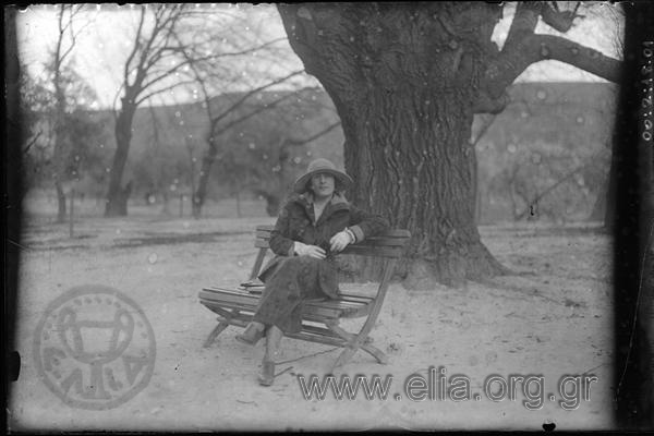 Γυναίκα κάθεται σε παγκάκι στον κήπο του Τατοΐου.