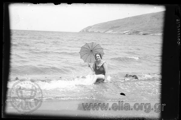Όρμος Κορθίου, η Ίρις Μηλιαράκη στην παραλία με ομπρέλα.