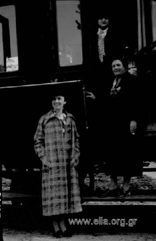 Η Ίρις και μία κυρία με καρώ παλτό κατεβαίνοντας από το τραίνο.