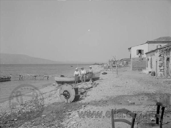 Iris and Giorgos on the beach with fishing boats
