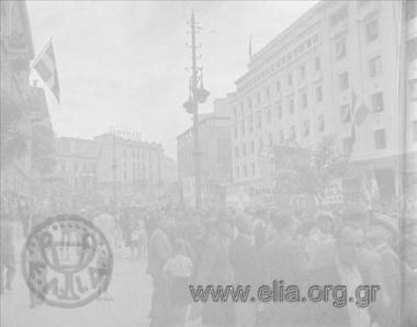 Απελευθέρωση. Πλήθος με πανό και σημαίες στην οδό Πανεπιστημίου (στο ύψος της οικίας Σλήμαν - σήμερα το Νομισματικό Μουσείο). Δεξιά, το κτίριο του Μετοχικού Ταμείου Στρατού.