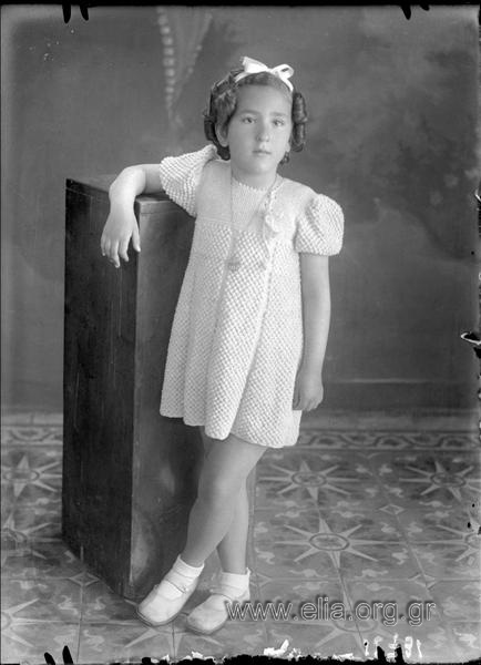 Πορτραίτο κοριτσιού με μπούκλες και πλεχτό φόρεμα.