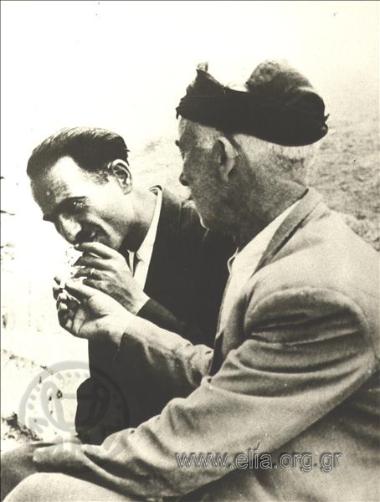 Ο Νίκος Καζαντζάκης και ένας κρητικός χωρικός καπνίζουν παρέα.