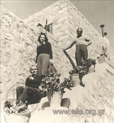 Ο Νίκος και η Ελένη Καζαντζάκη στο σπίτι τους στο Σταυρό. Στην κορυφή της σκάλας, ο Τάκης Καλμούχος.