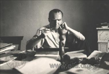 Ο Νίκος Καζαντζάκης μελετά στο γραφείο του, στη 