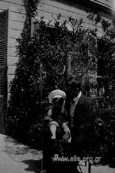 Ο Ιπποκράτης Παπαβασιλείου κρατά στα γόνατά του το γιό του, Δημήτρη.