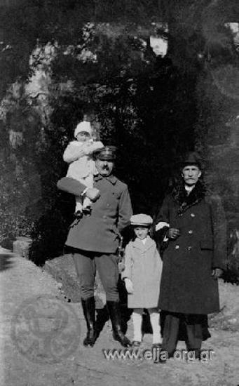Ο Ιπποκράτης Παπαβασιλείου (ταγματάρχης Μηχανικού) κρατά στον ώμο του την κόρη του, Υρώ. Δίπλα του ο γιος του, Δημήτρης, και ηλικιωμένος άνδρας.