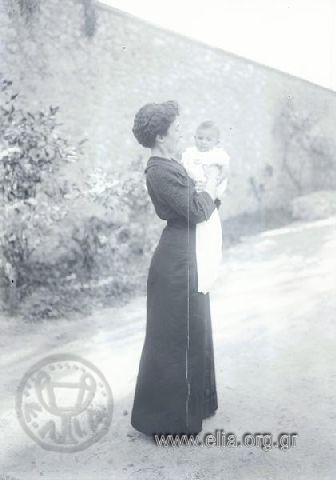 Η Αλεξάνδρα Παπαβασιλείου με την κόρη της, μωρό. Λήψη σε κάποια αλέα των θερινών ανακτόρων.