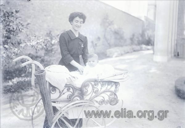 Alexandra Papavasileiou and her daughter, Yro, in a baby stroller . View of an alley of the summer palace.