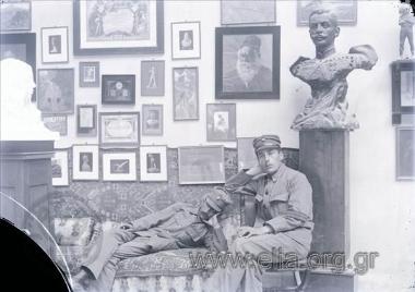 Στρατιώτες στο ατελιέ του γλύπτη, κάτω από την προτομή του Παύλου Μελά. Ξαπλωμένος αριστερά ο ποιητής Λάμπρος Πορφύρας.