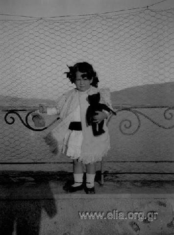 Little Eirini N. Makka holding a doll.
