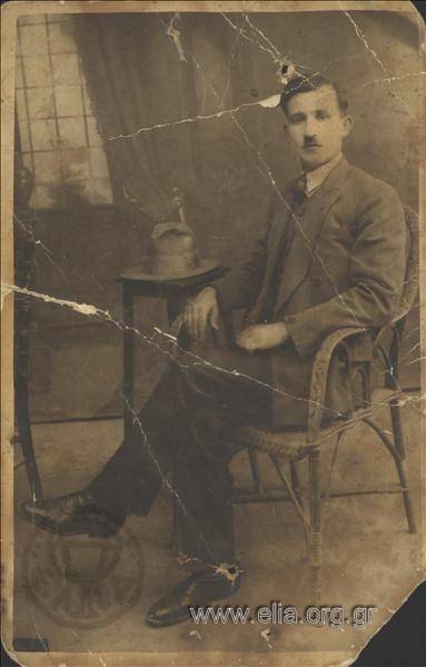 Πορτραίτο άνδρα σε ψάθινη πολυθρόνα.
