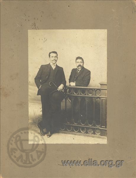 Portrait of two men at the rail of a photographic studio.